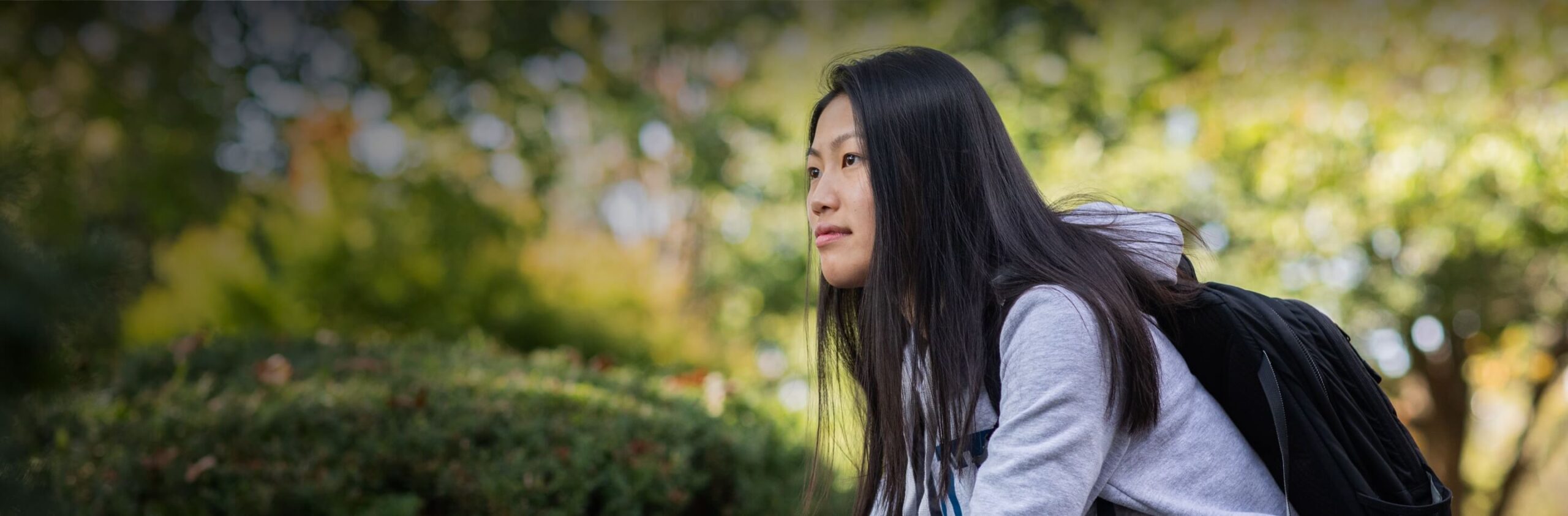 Our founder page hero image of Asian American student looking on.