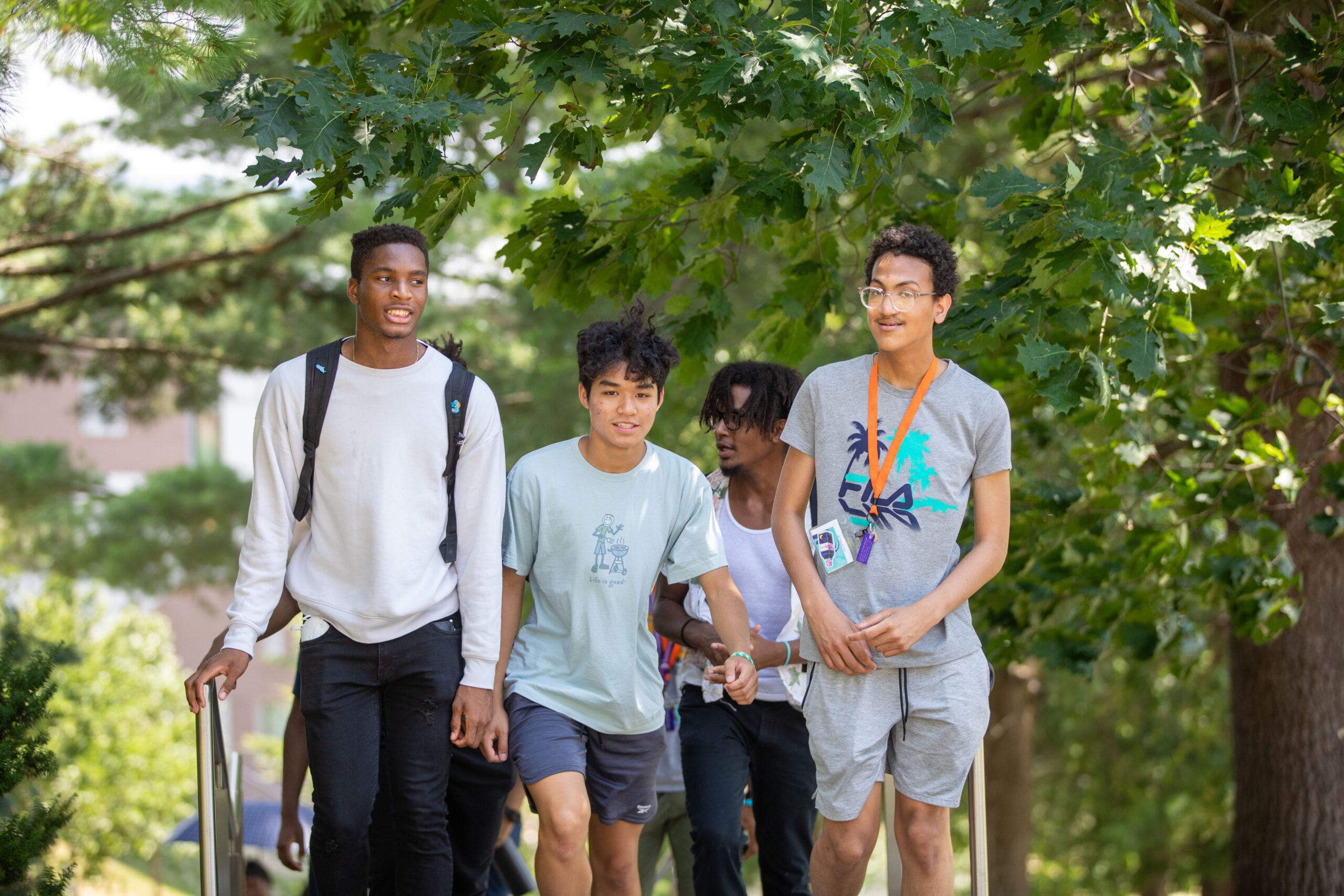 header image for research round up edition 4. Four male high school students visit college campus.